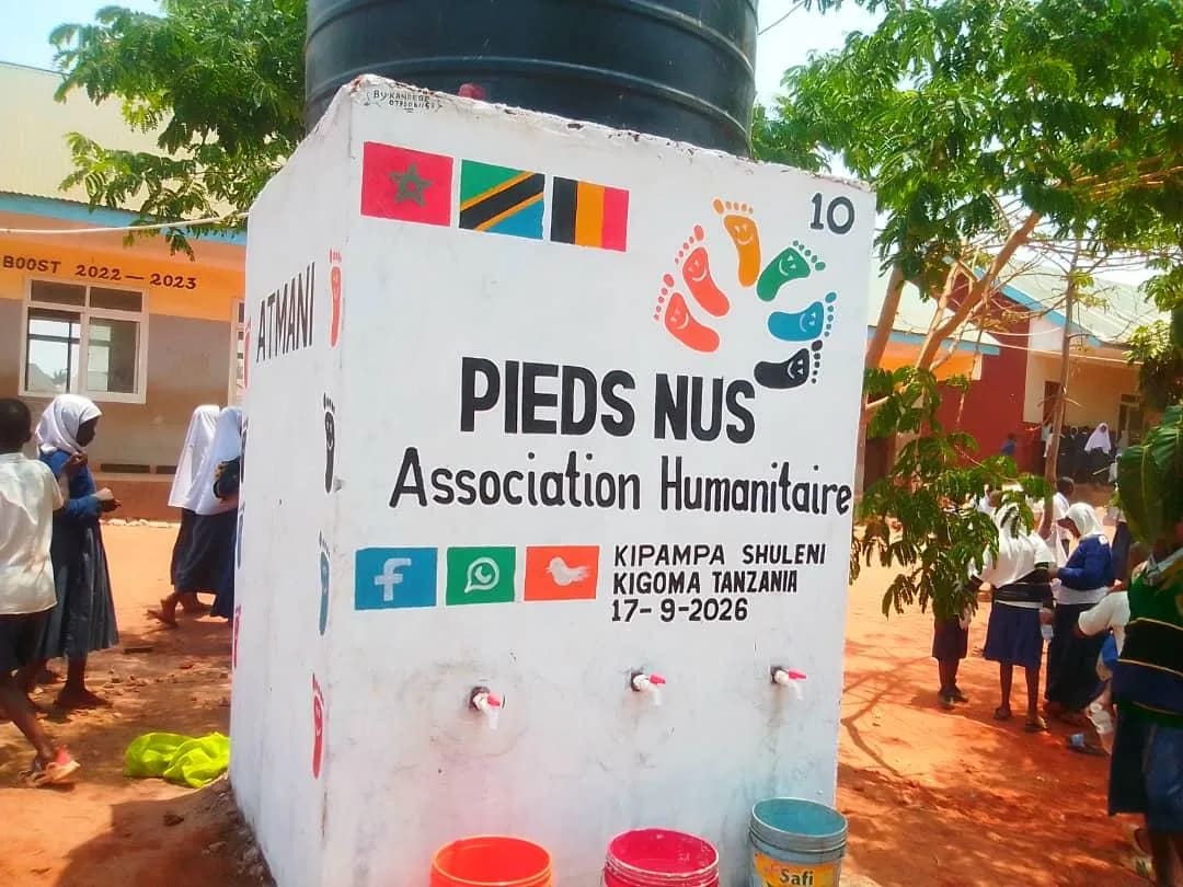 Élèves devant le point d'eau de l'école de Kipampa, à Kigoma, et ses trois robinets