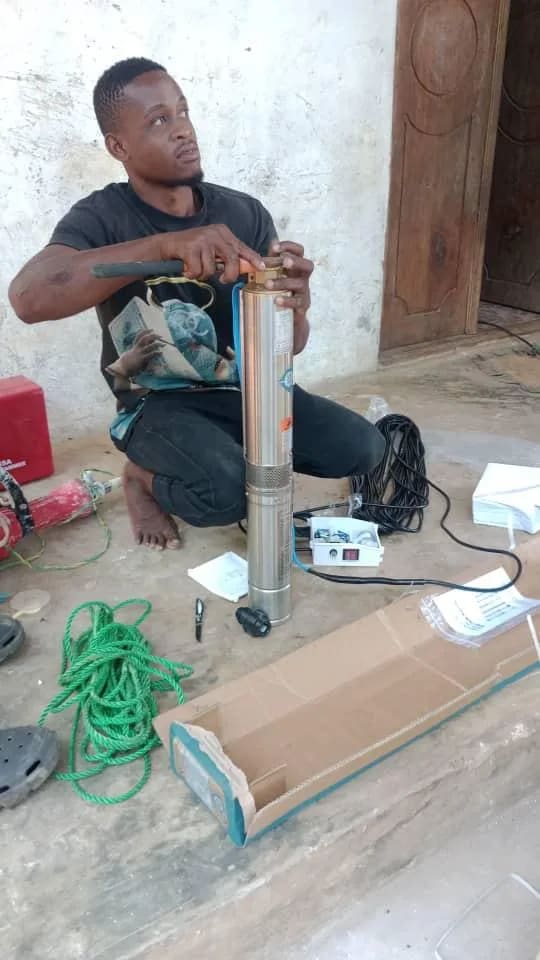 Un technicien prépare une pompe immergée et son câblage avant l'installation