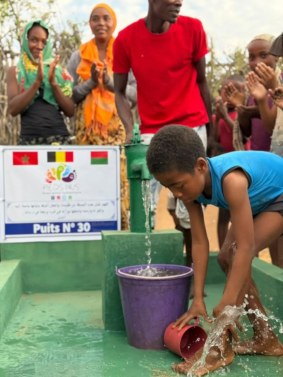 Un enfant renverse un seau d'eau au puits n° 30, l'eau éclabousse le bassin