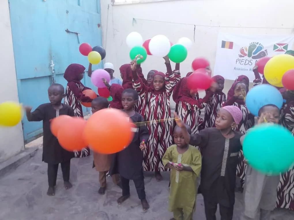 Enfants avec des ballons colorés dans une cour de Bujumbura