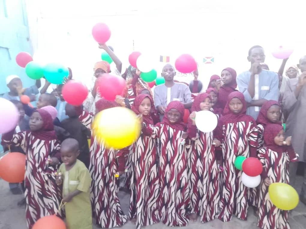 Enfants en tenues identiques, ballons colorés à la main, à Bujumbura