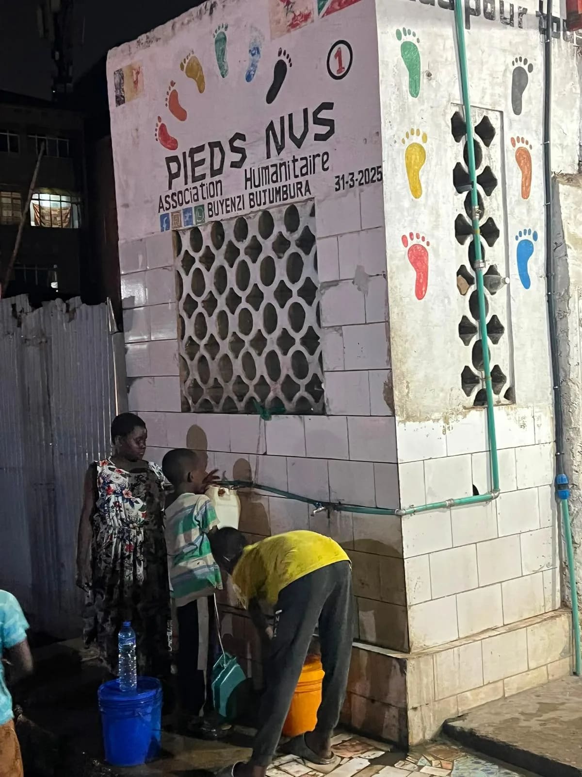 Point d'eau Pieds Nus n° 1 à Buyenzi, Bujumbura, daté du 31 mars 2025 : des habitants viennent remplir leurs seaux